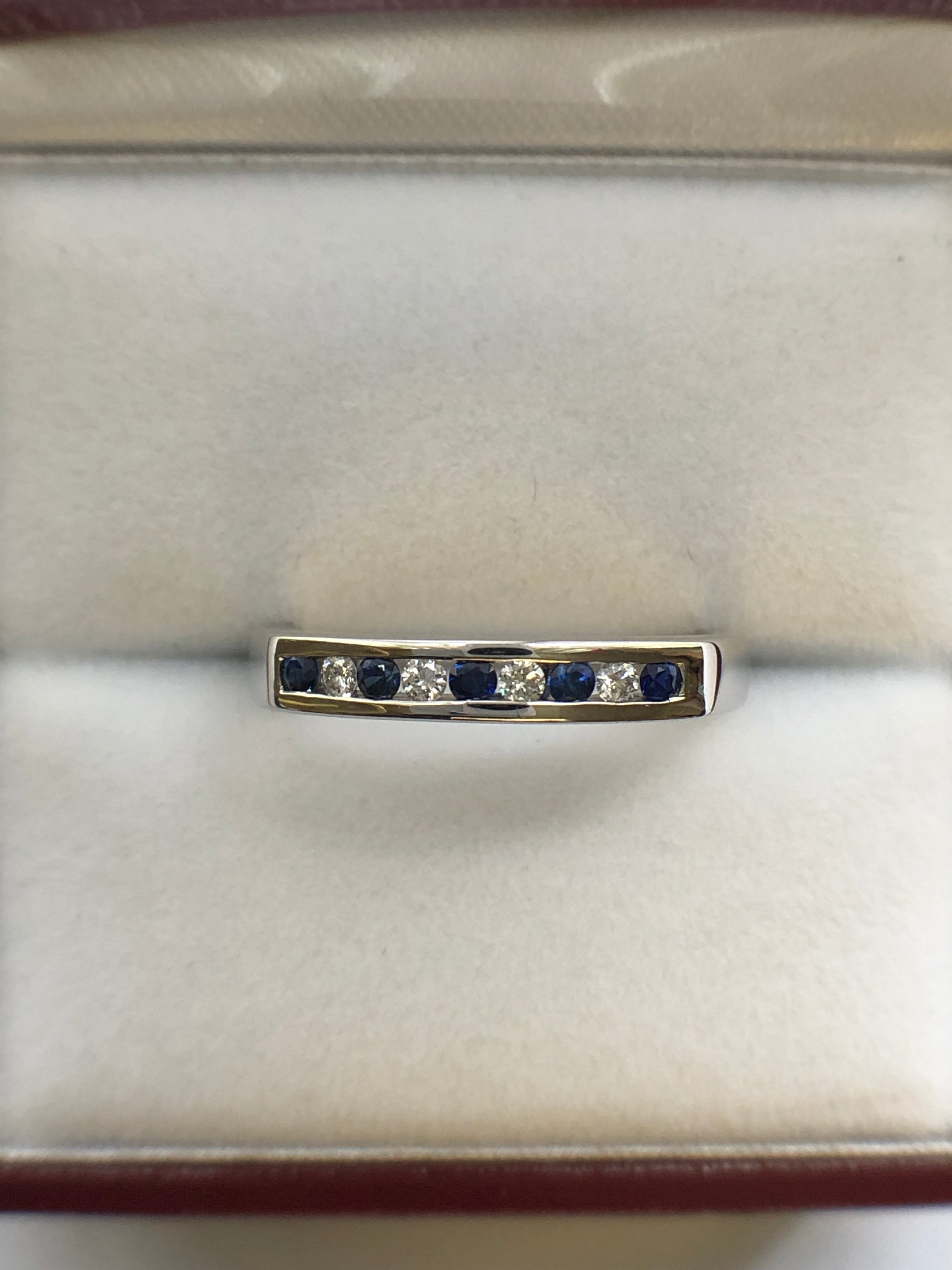 A 9ct white gold sapphire and diamond half eternity ring