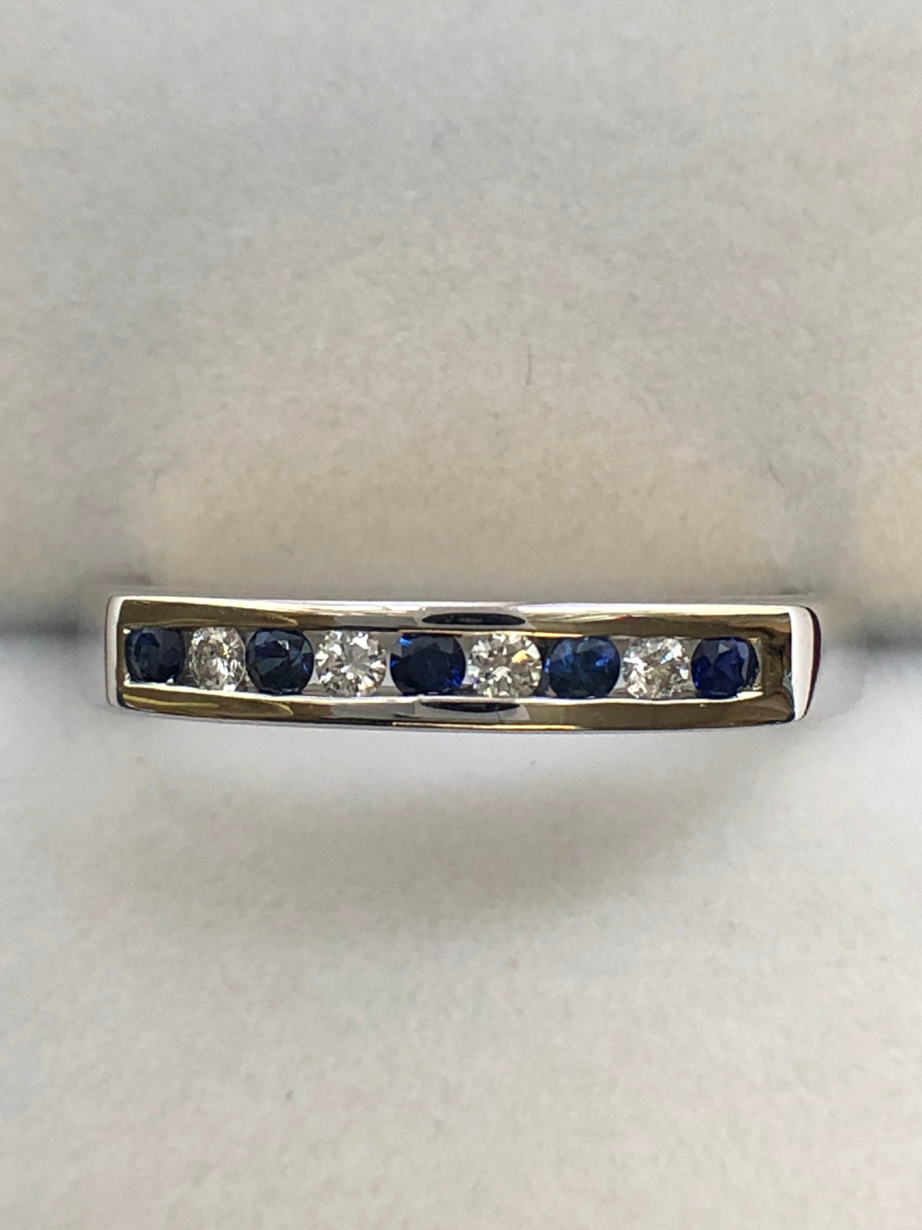 A 9ct white gold sapphire and diamond half eternity ring