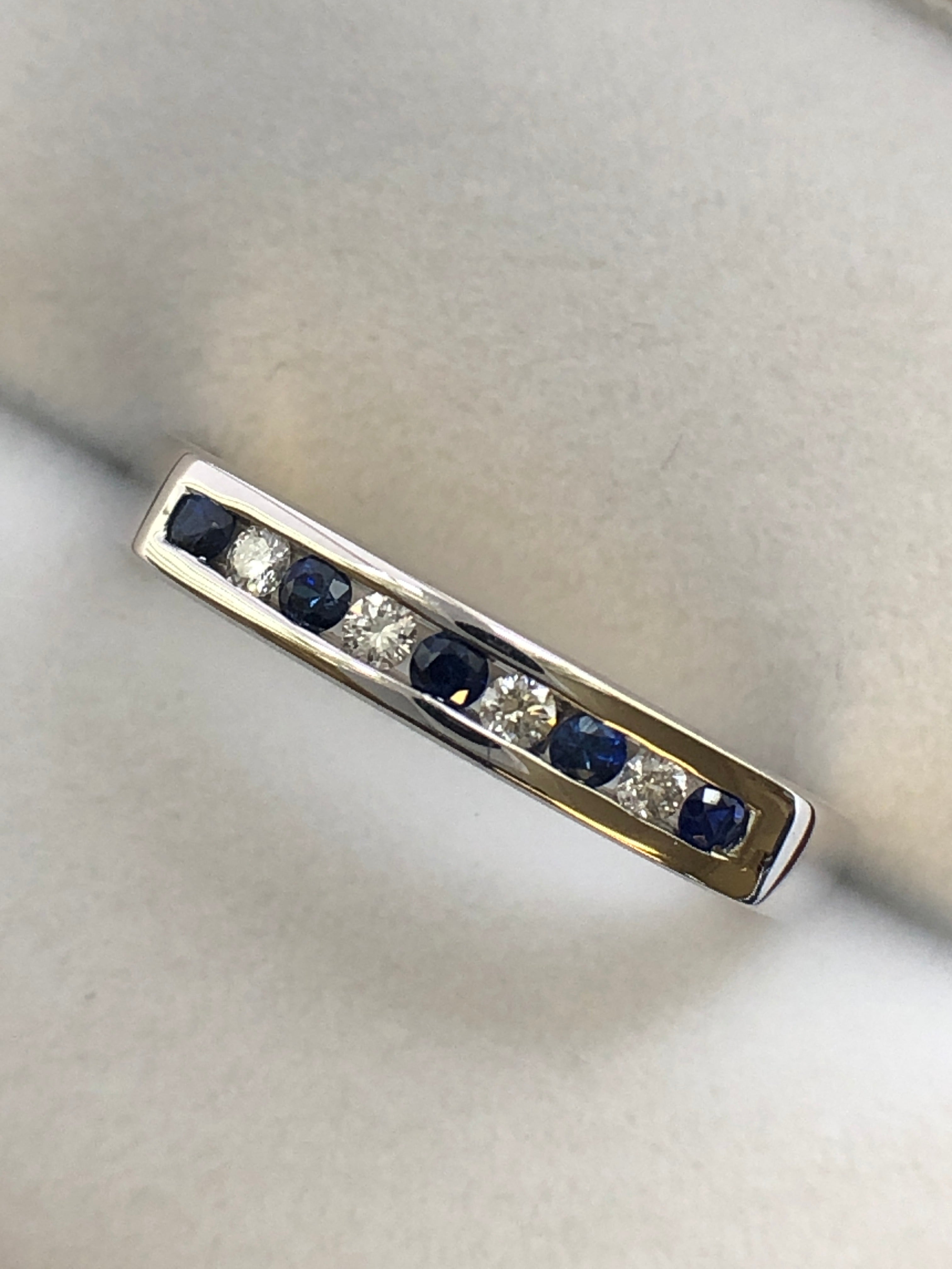 A 9ct white gold sapphire and diamond half eternity ring