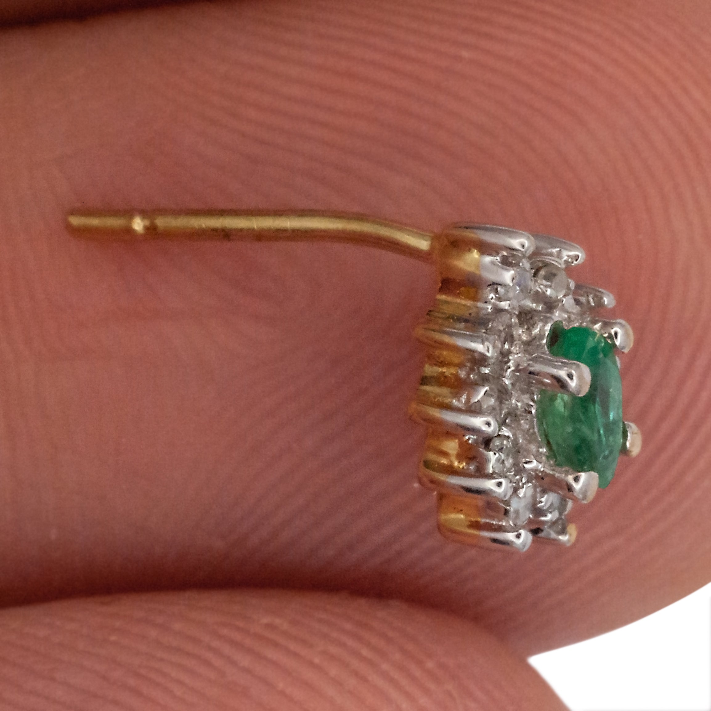 A 9ct white gold emerald and diamond earring.