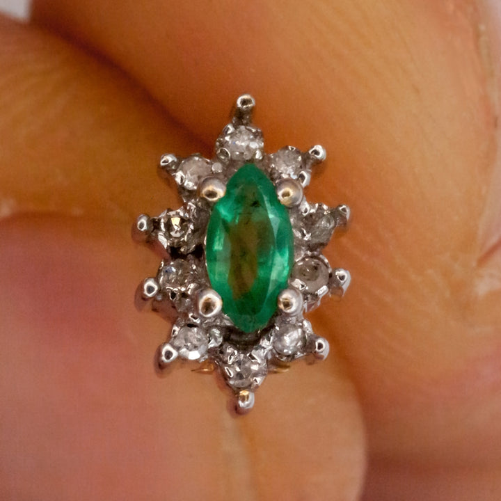 A 9ct white gold emerald and diamond earring.