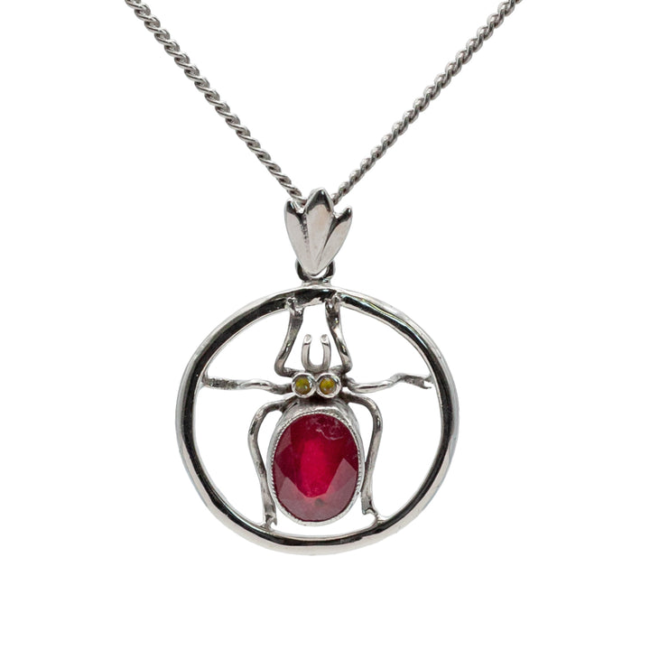 An antique 18ct white gold ruby and amber beetle pendant.