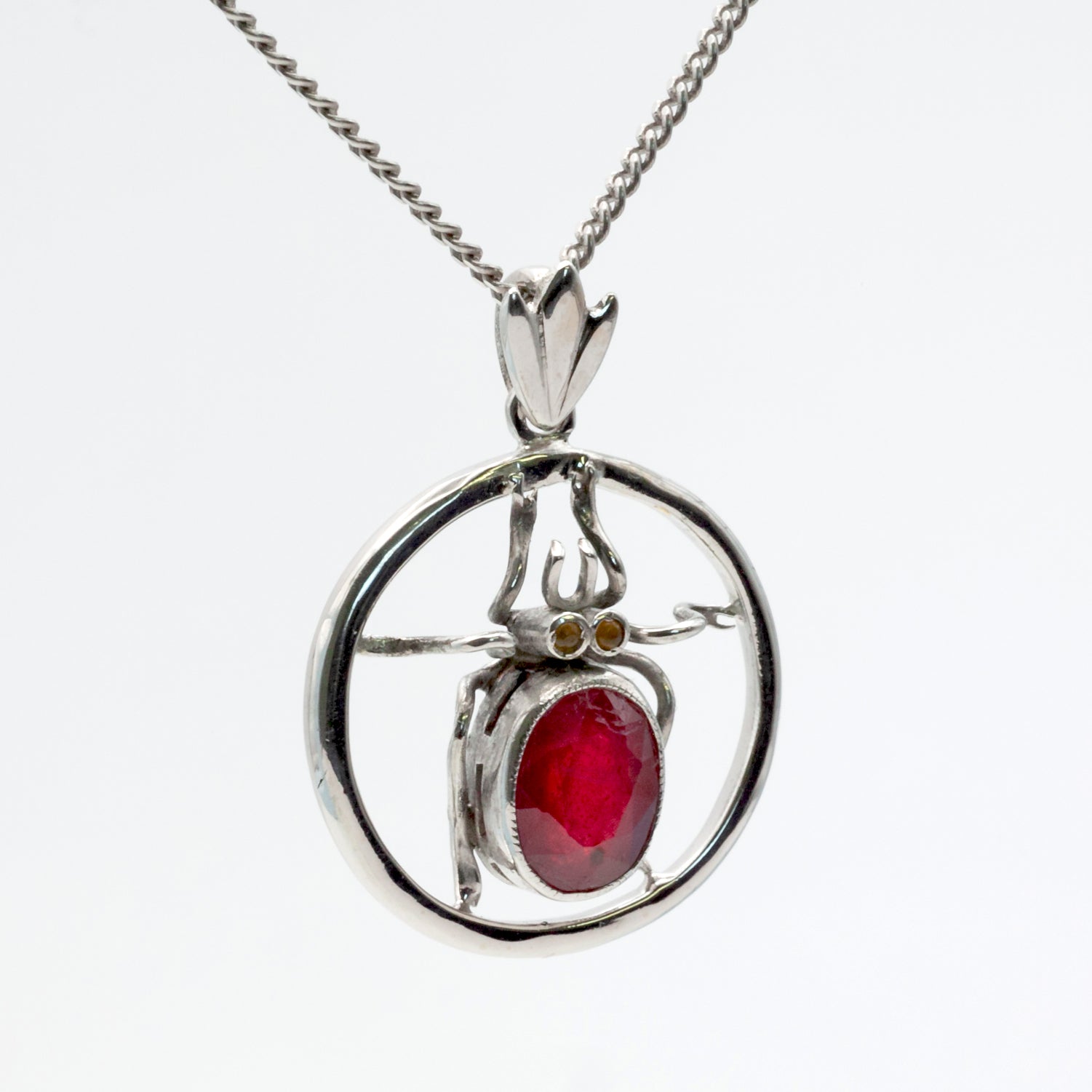 An antique 18ct white gold ruby and amber beetle pendant.