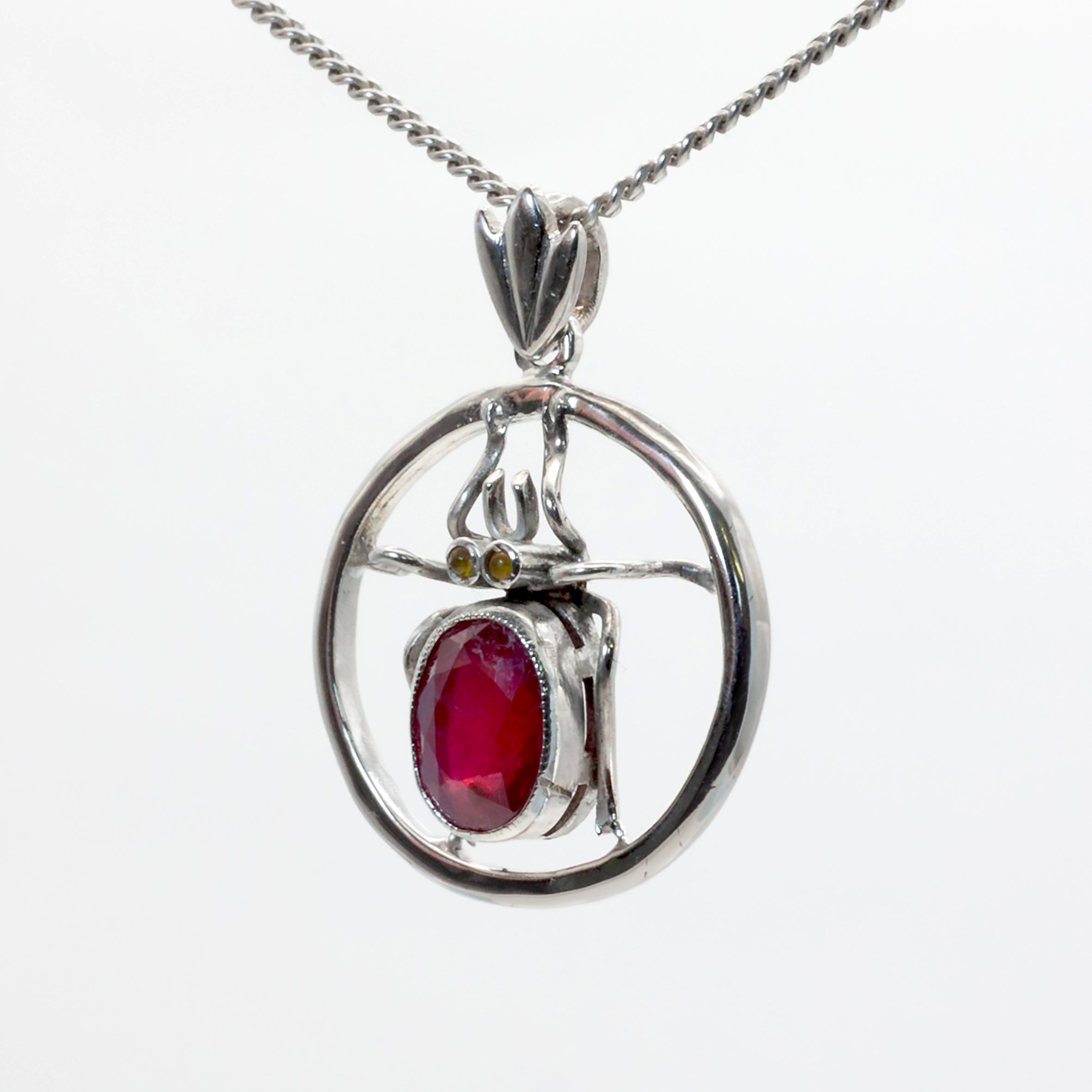 An antique 18ct white gold ruby and amber beetle pendant.
