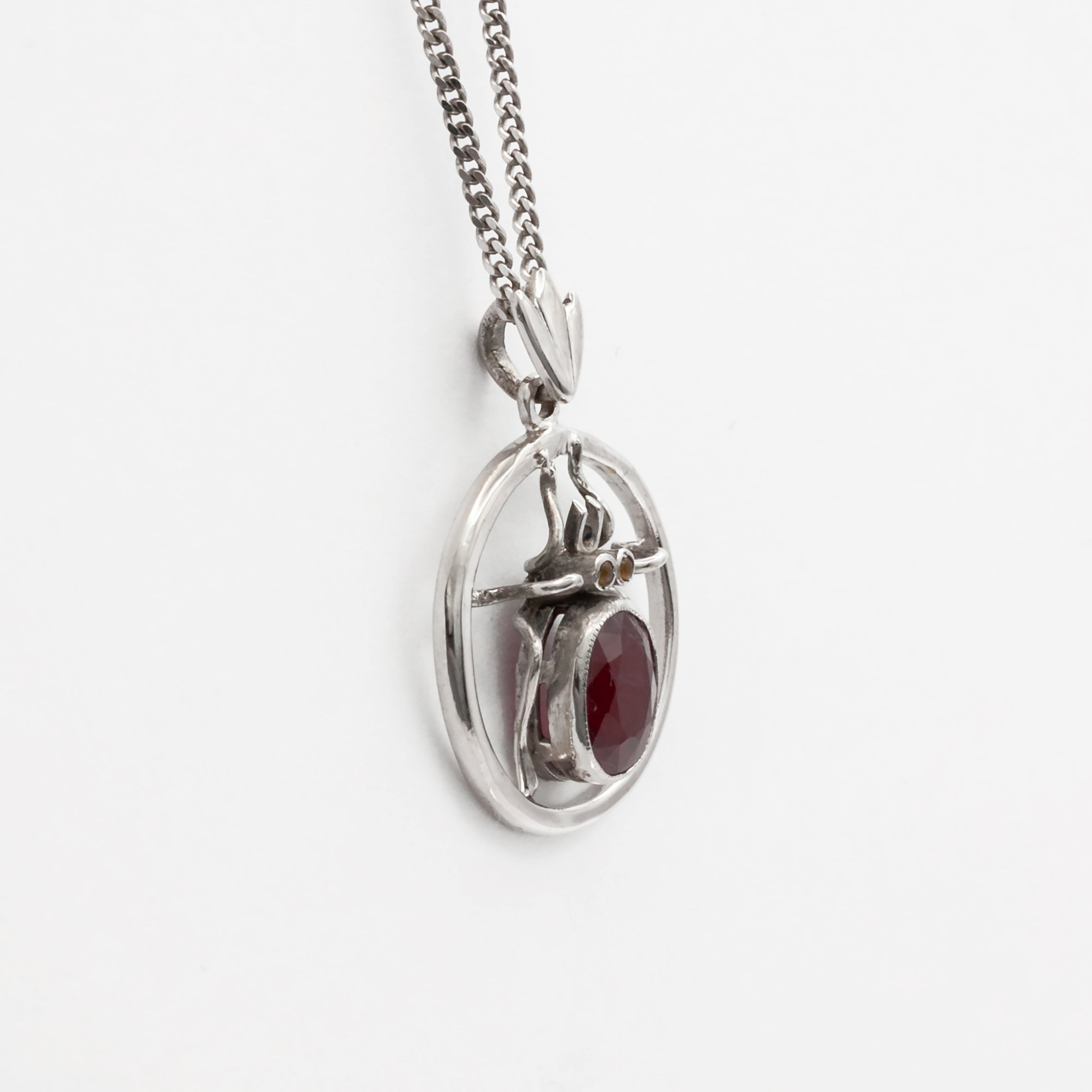 An antique 18ct white gold ruby and amber beetle pendant.
