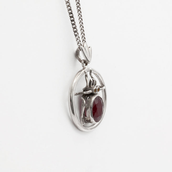 An antique 18ct white gold ruby and amber beetle pendant.