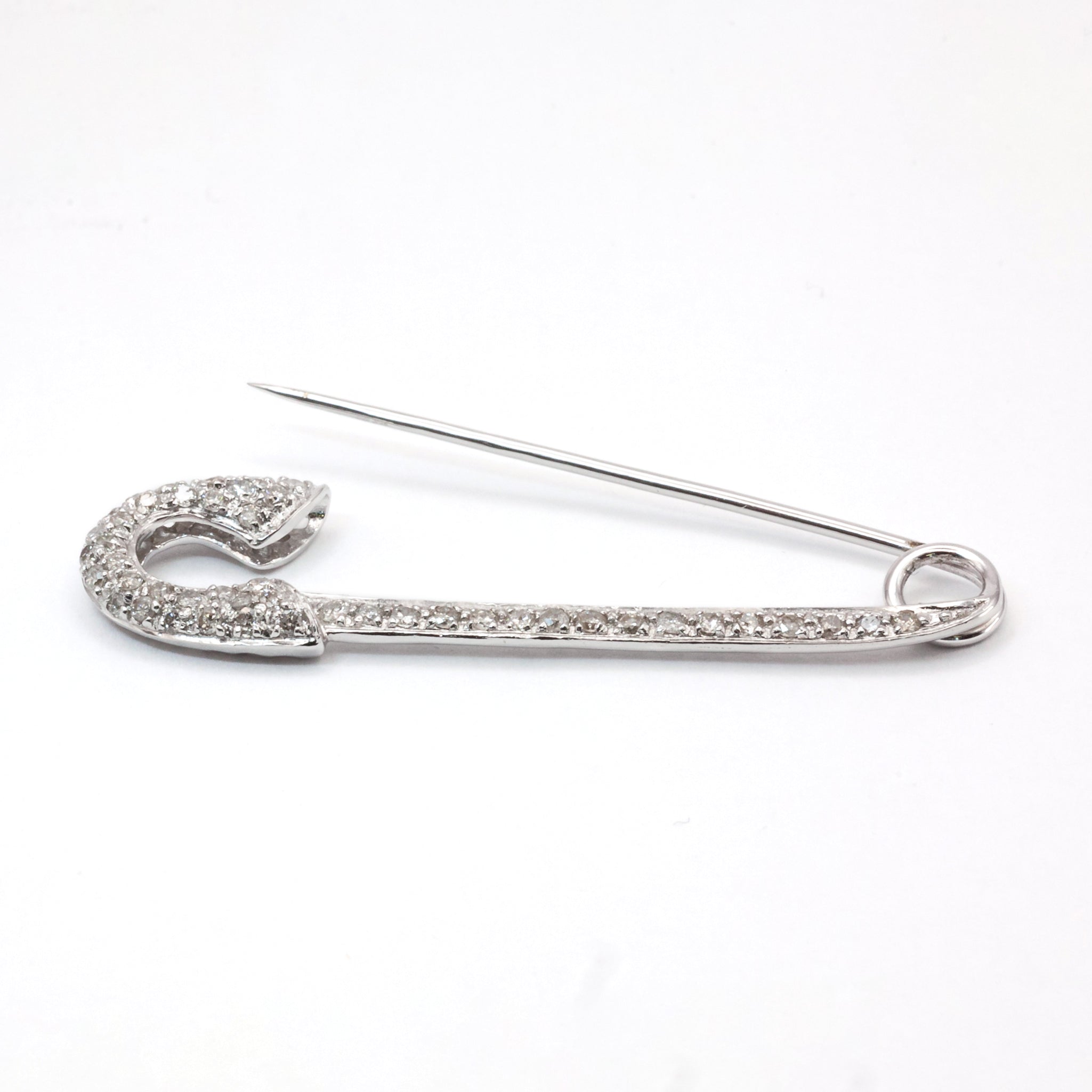 An antique 18ct white gold diamond safety pin brooch.