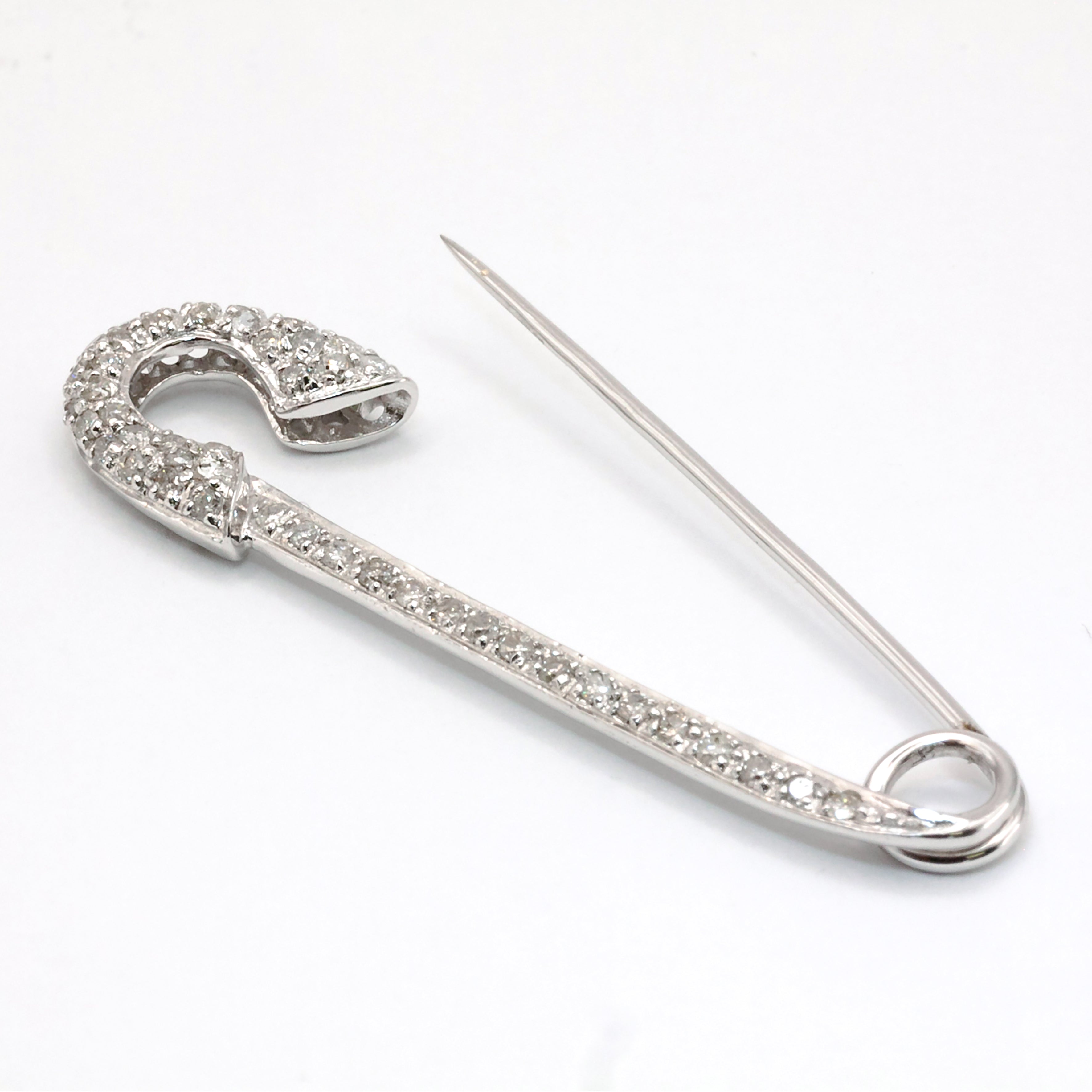 An antique 18ct white gold diamond safety pin brooch.