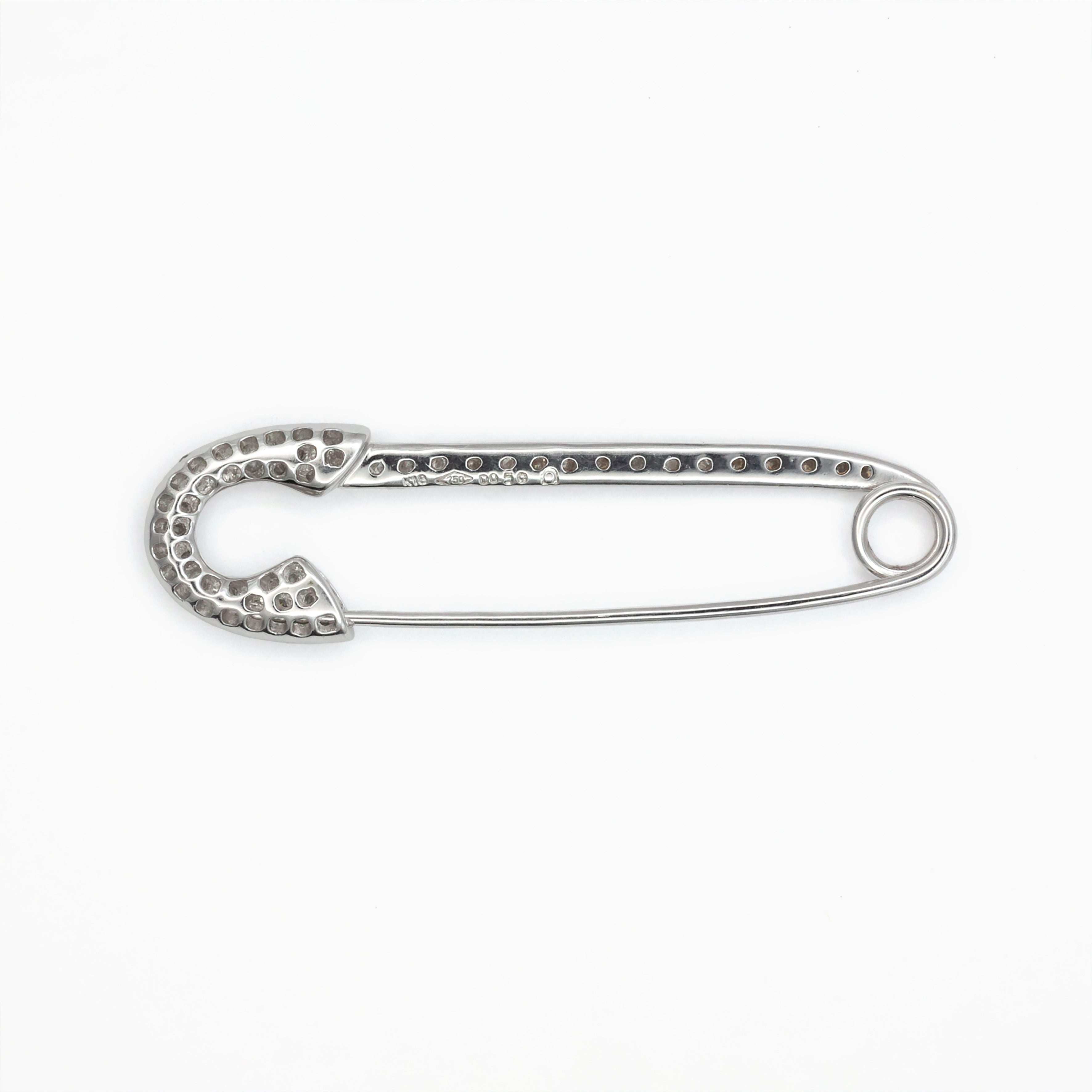 An antique 18ct white gold diamond safety pin brooch.