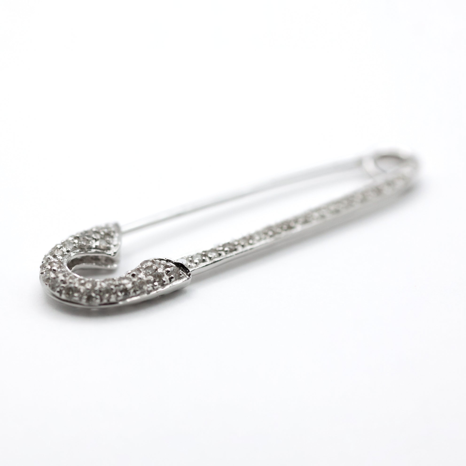 An antique 18ct white gold diamond safety pin brooch.