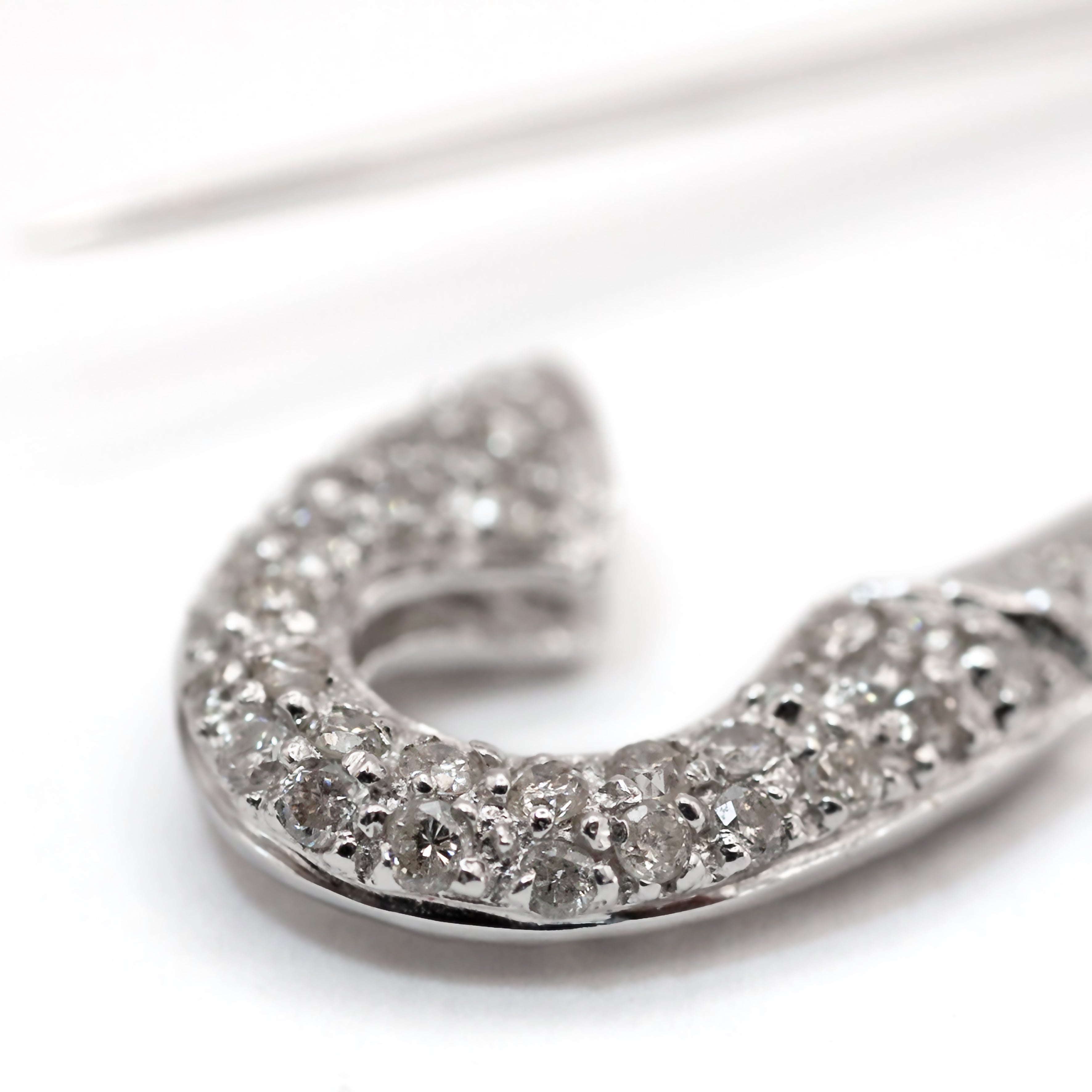 An antique 18ct white gold diamond safety pin brooch.