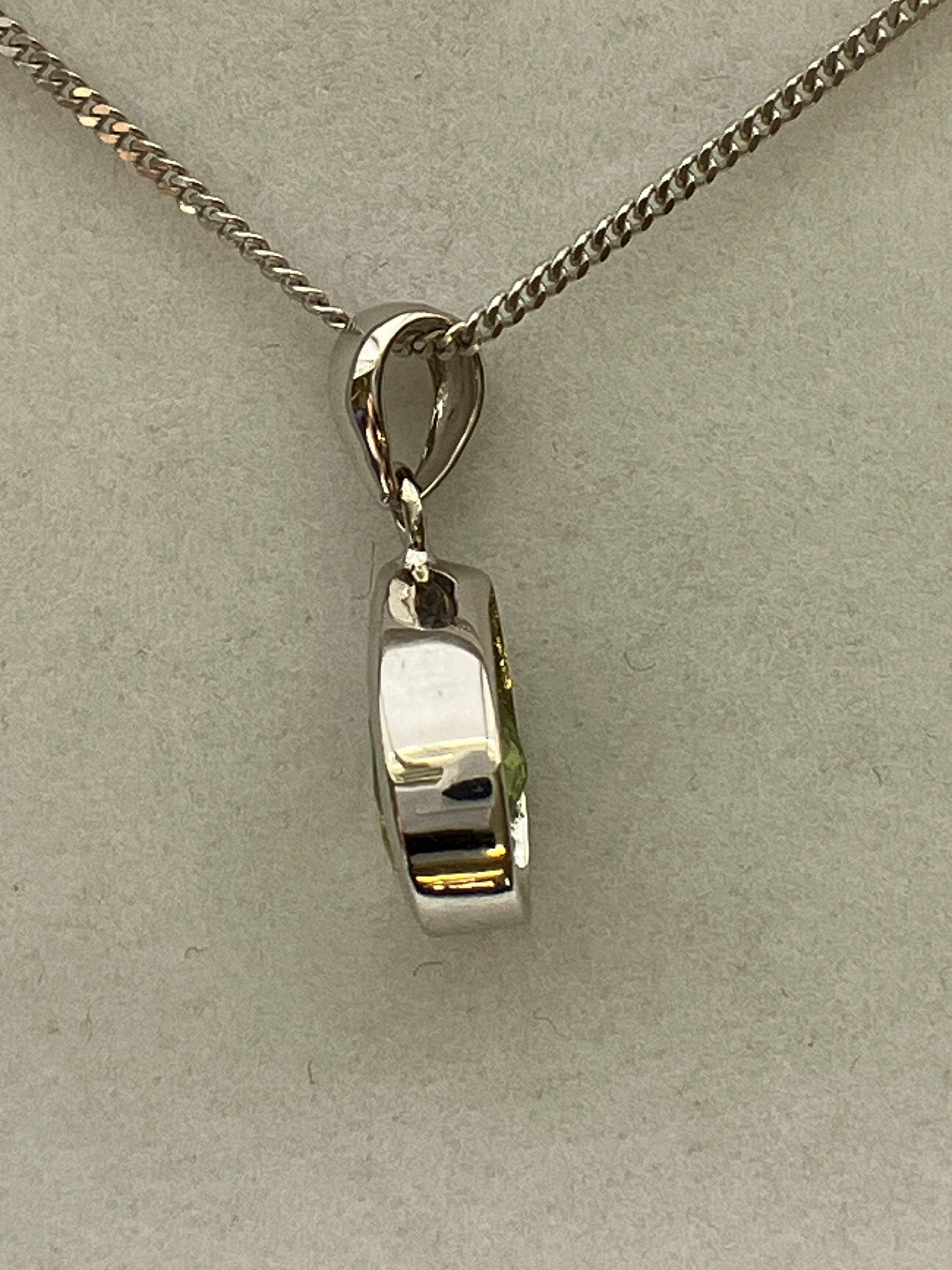 A 9ct white gold peridot pendant