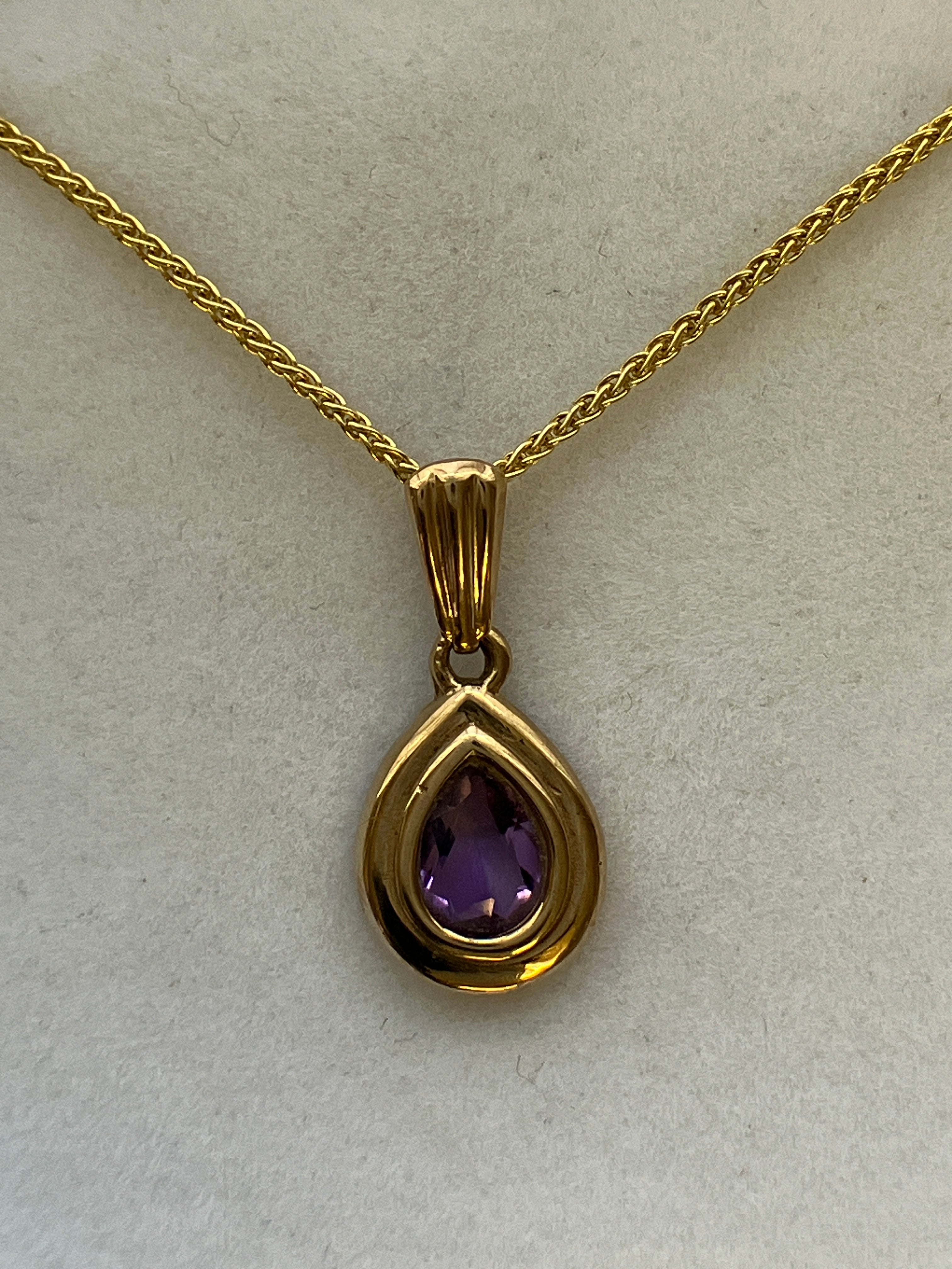 A 9ct gold amethyst pendant on a 9ct gold chain