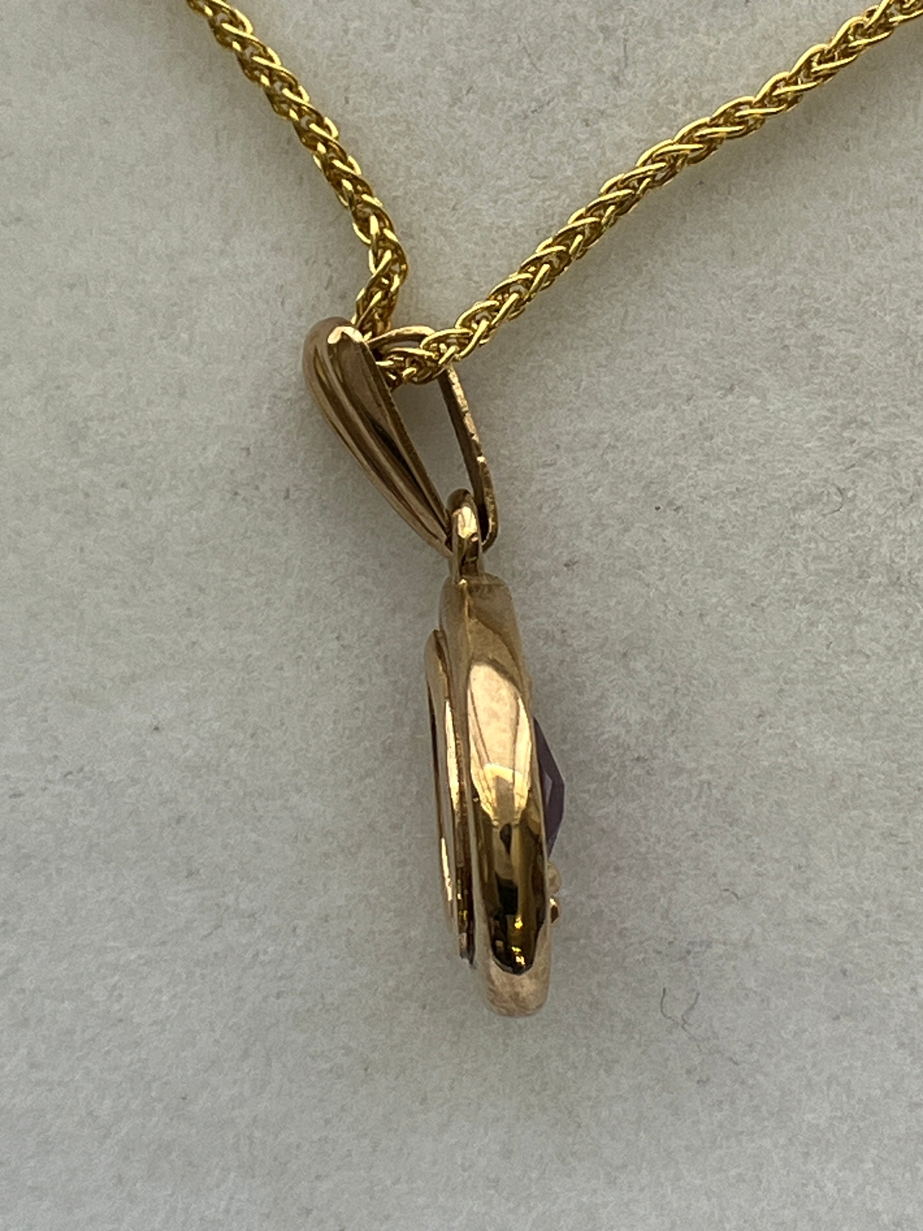 A 9ct gold amethyst pendant on a 9ct gold chain